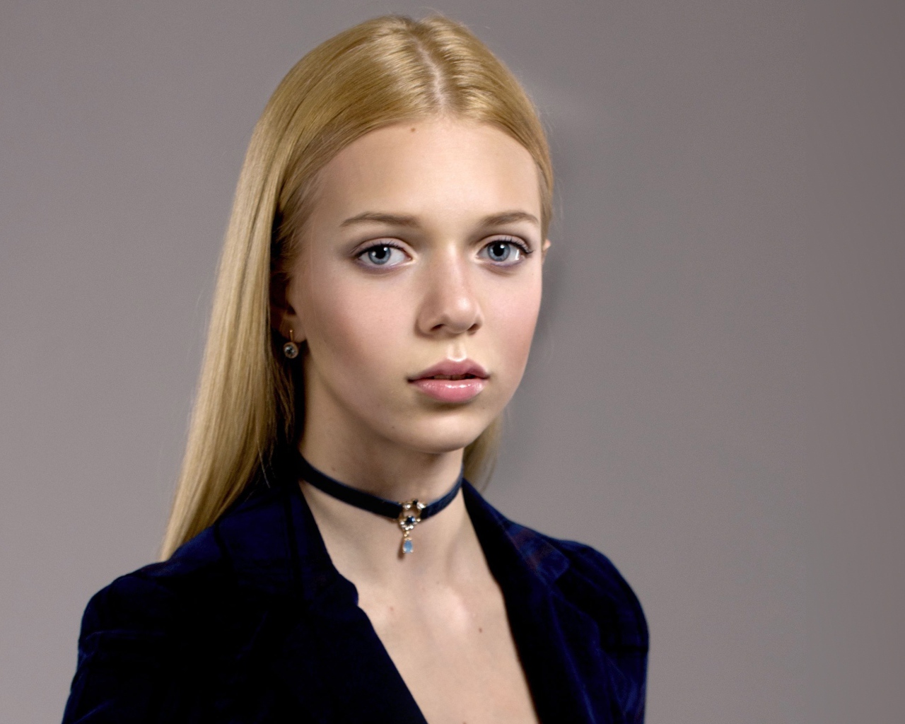 Нежная голубоглазая девушка с украшением на шее 