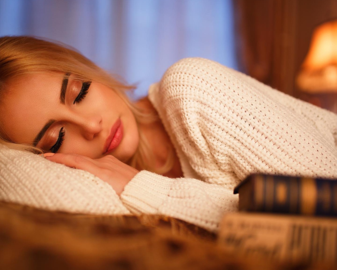 Нежная спящая блондинка в белом свитере 