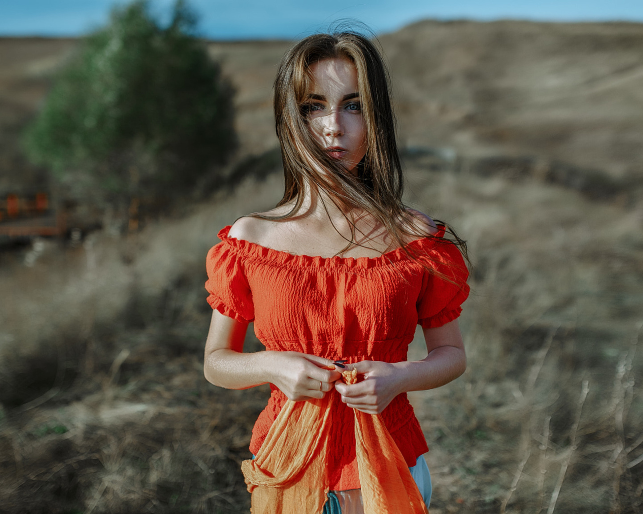 Ветер развивает волосы красивой девушке шатенке 