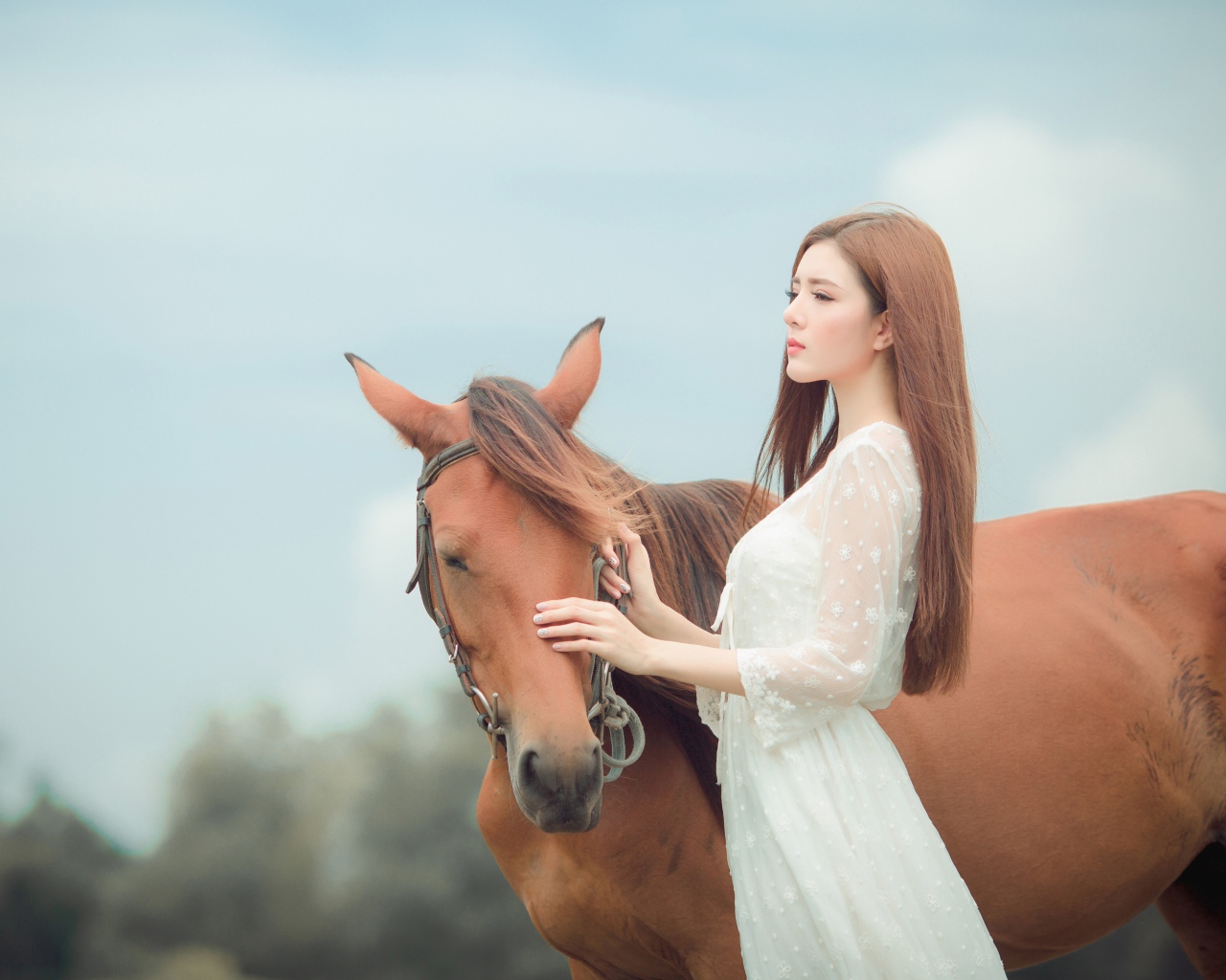 Молодая азиатка в белом платье с лошадью 