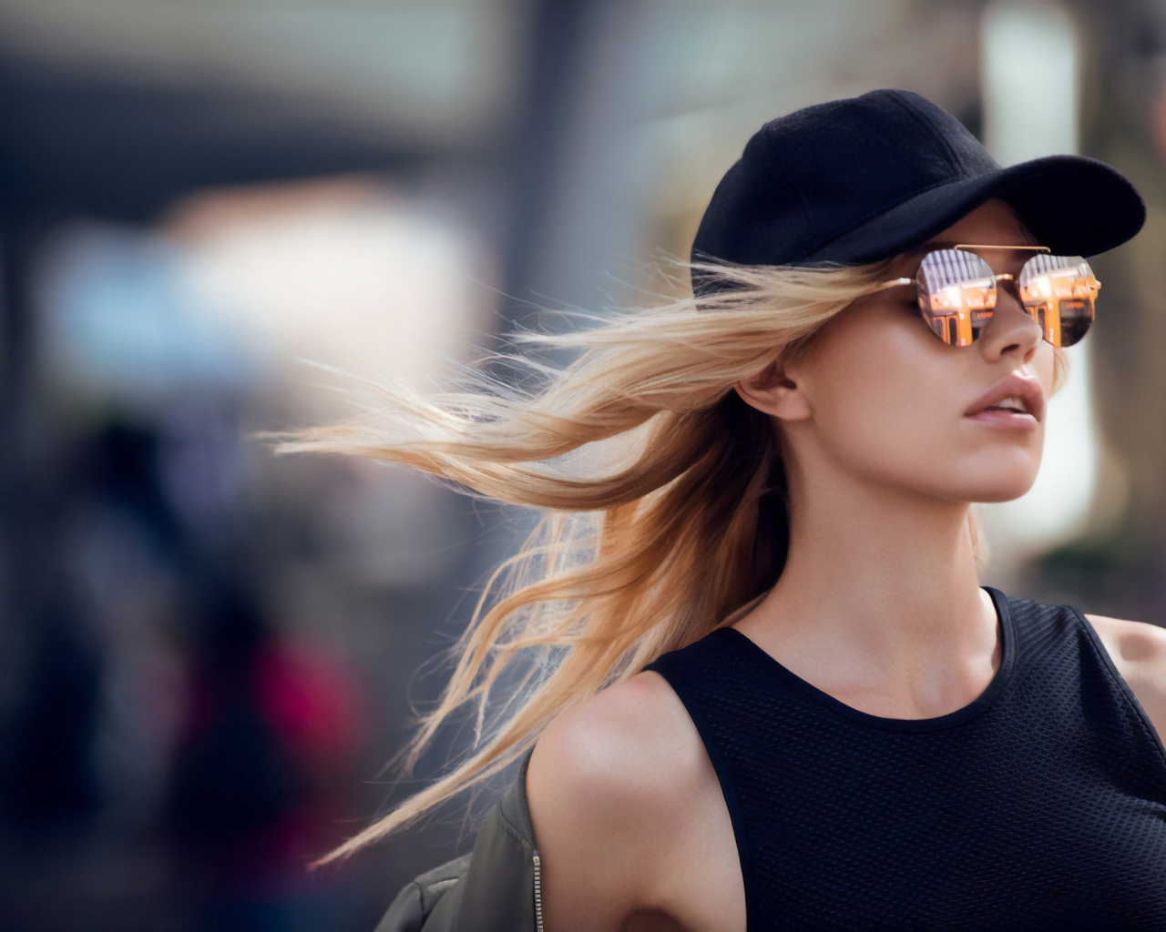 Молодая блондинка в солнечных очках и черной кепке 