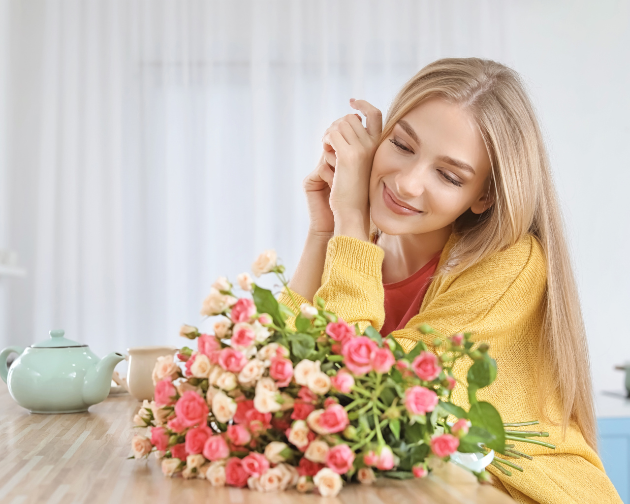 Молодая блондинка с букетом роз на столе