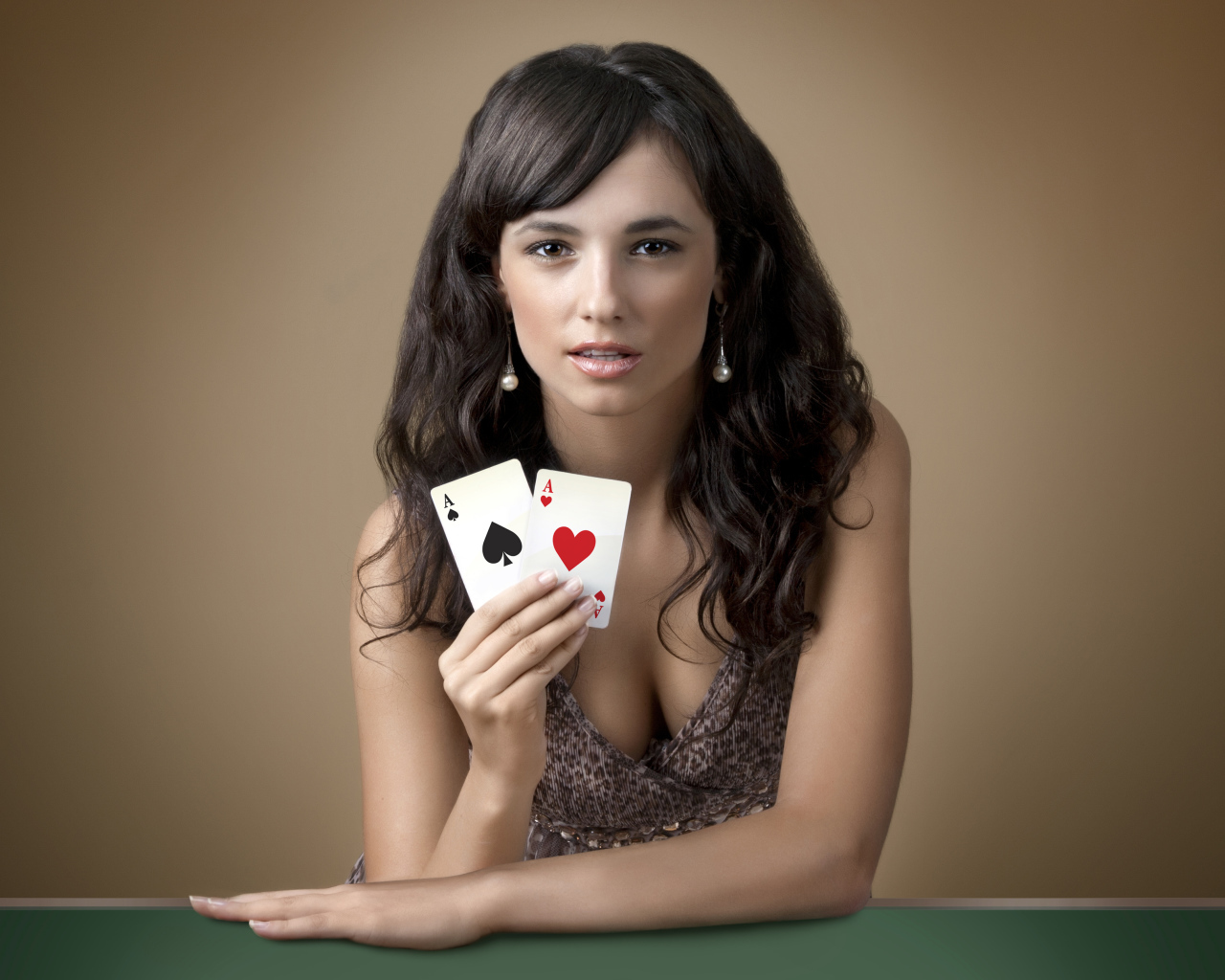 Молодая брюнетка с двумя карточными тузами в руке