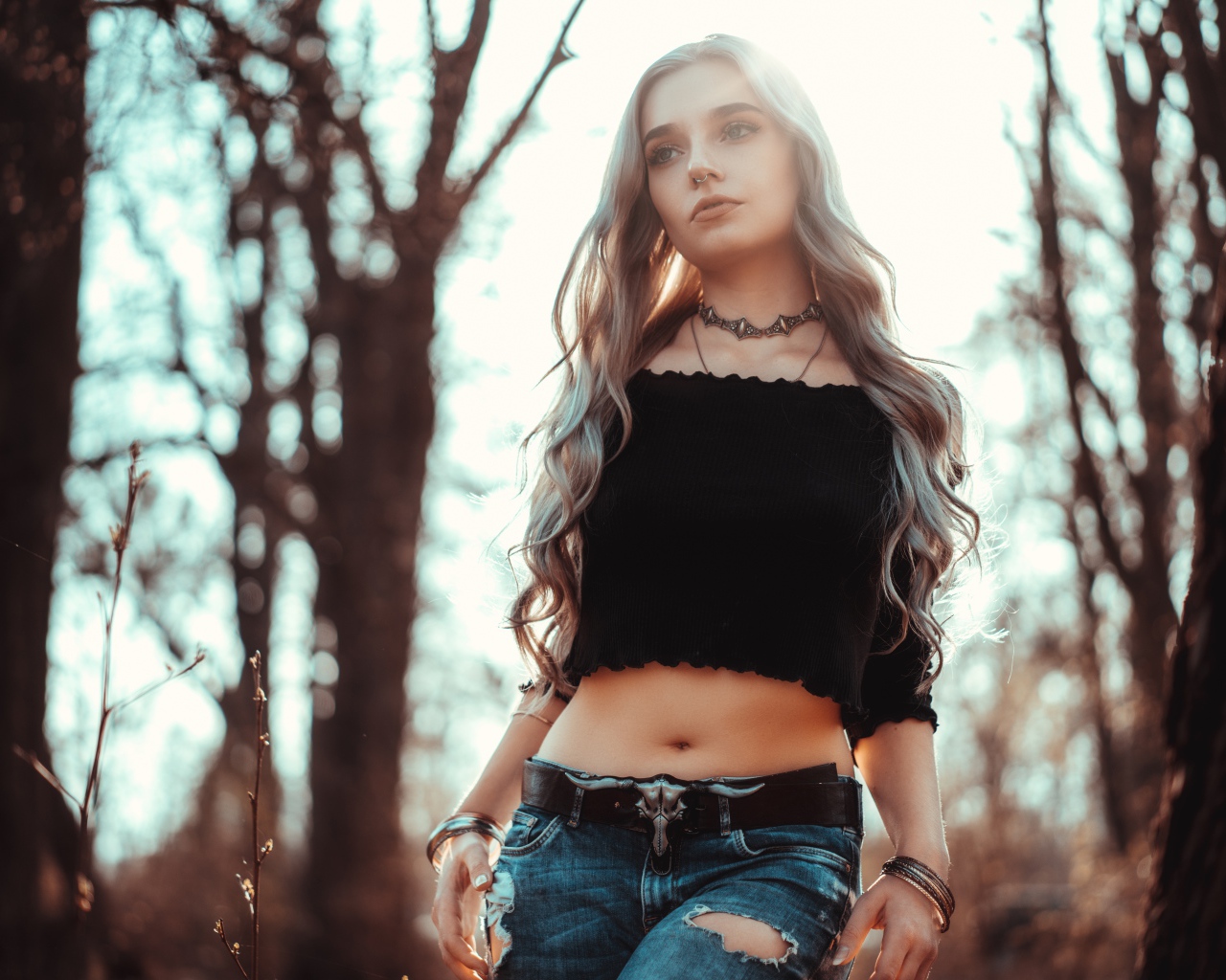 Молодая девушка в рваных джинсах с пирсингом в носу