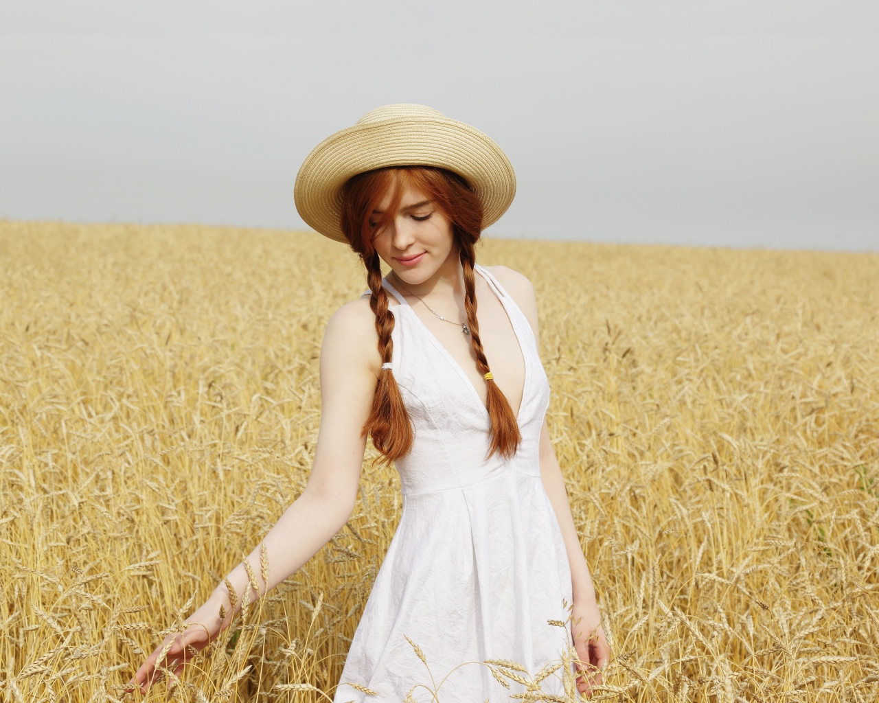 Молодая девушка в белом платье на поле с пшеницей
