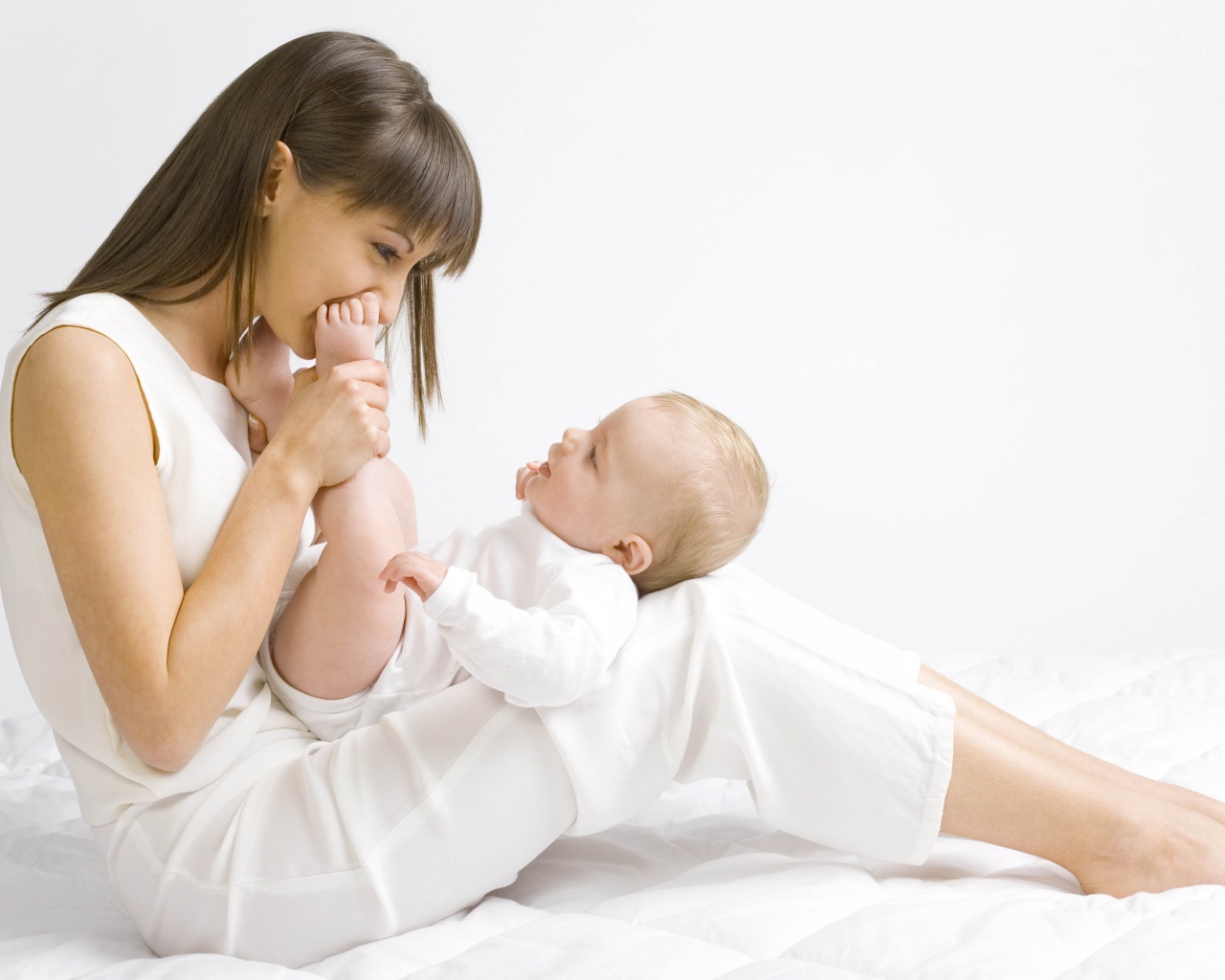 Молодая девушка в белом с младенцем