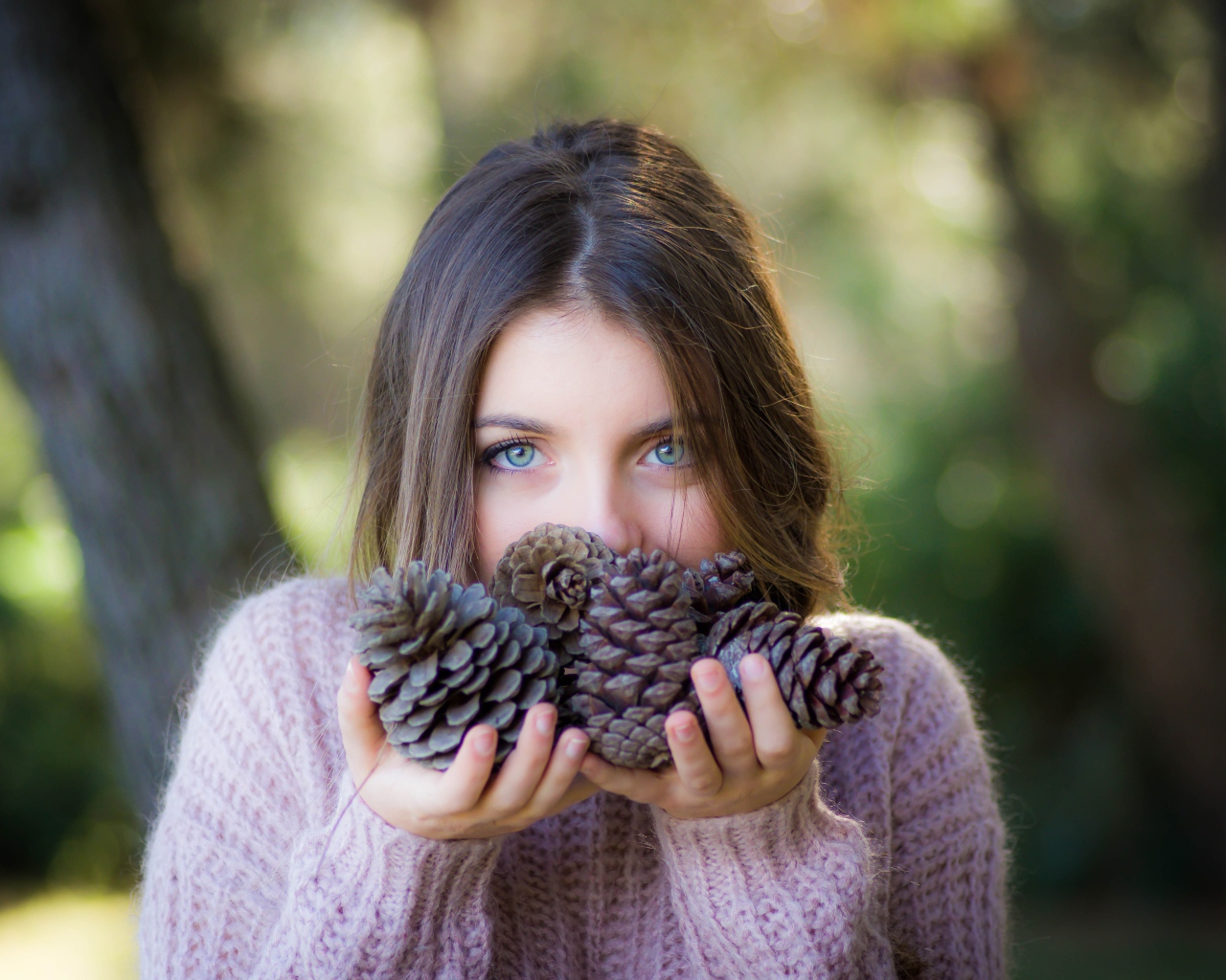 Молодая девушка с шишками в руках