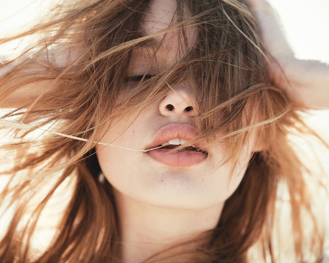 Молодая девушка с распущенными волосами на ветру