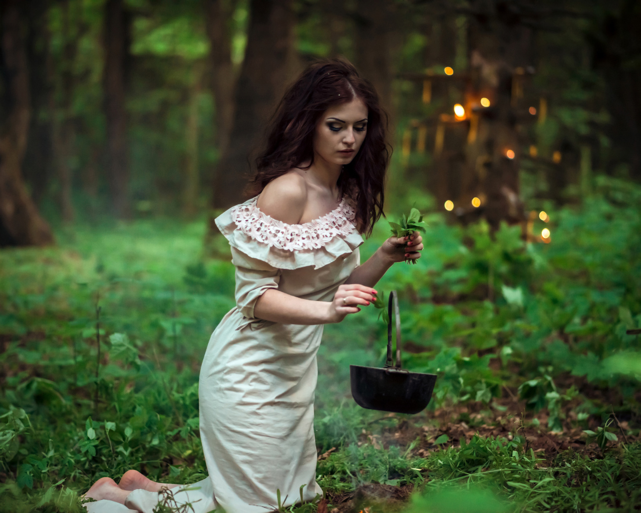 Молодая девушка колдунья варит зелье в лесу