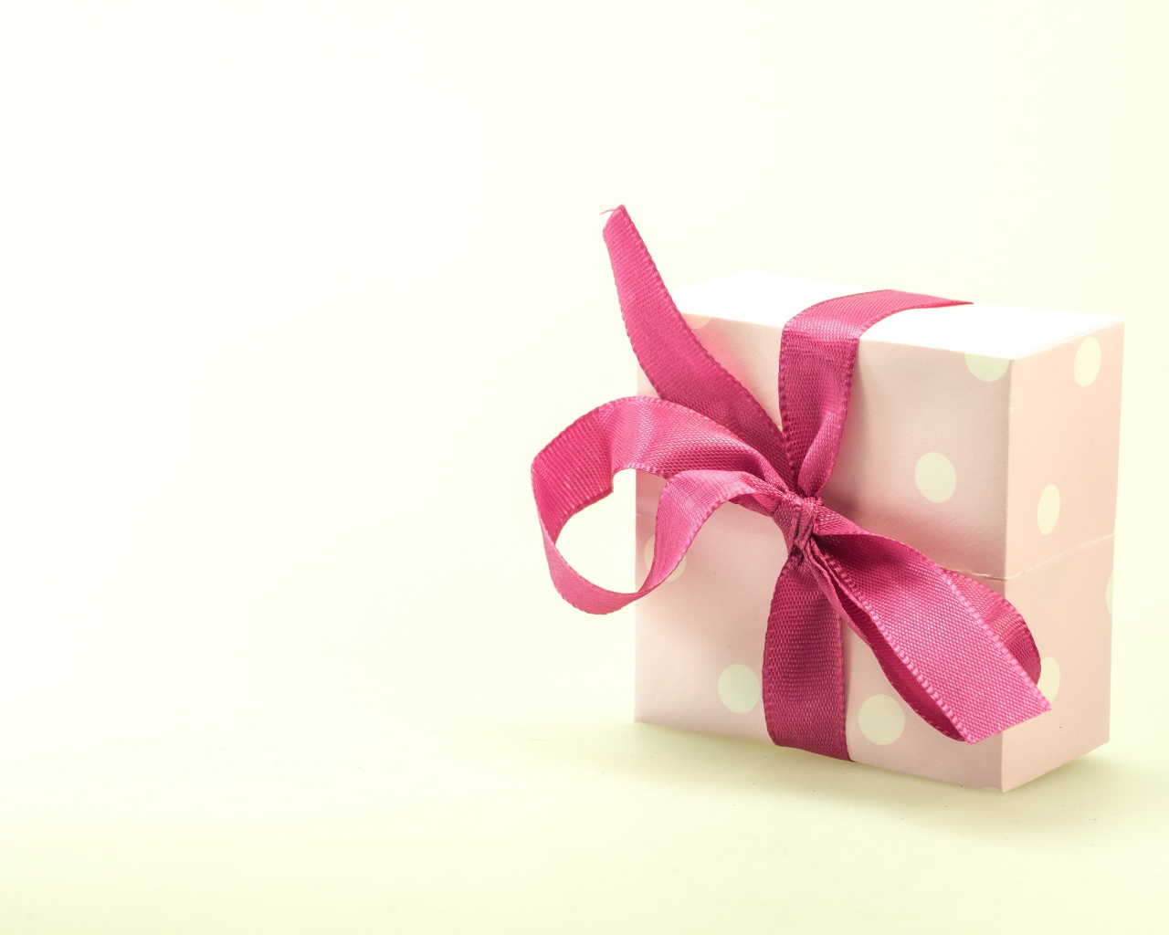 Подарочная коробка с розовым бантом на белом фоне