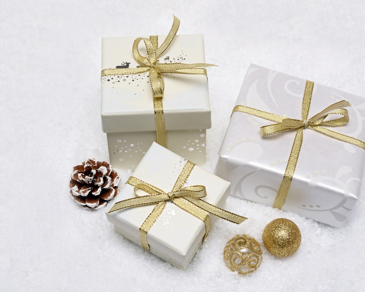 Three gift boxes with golden ribbon bows