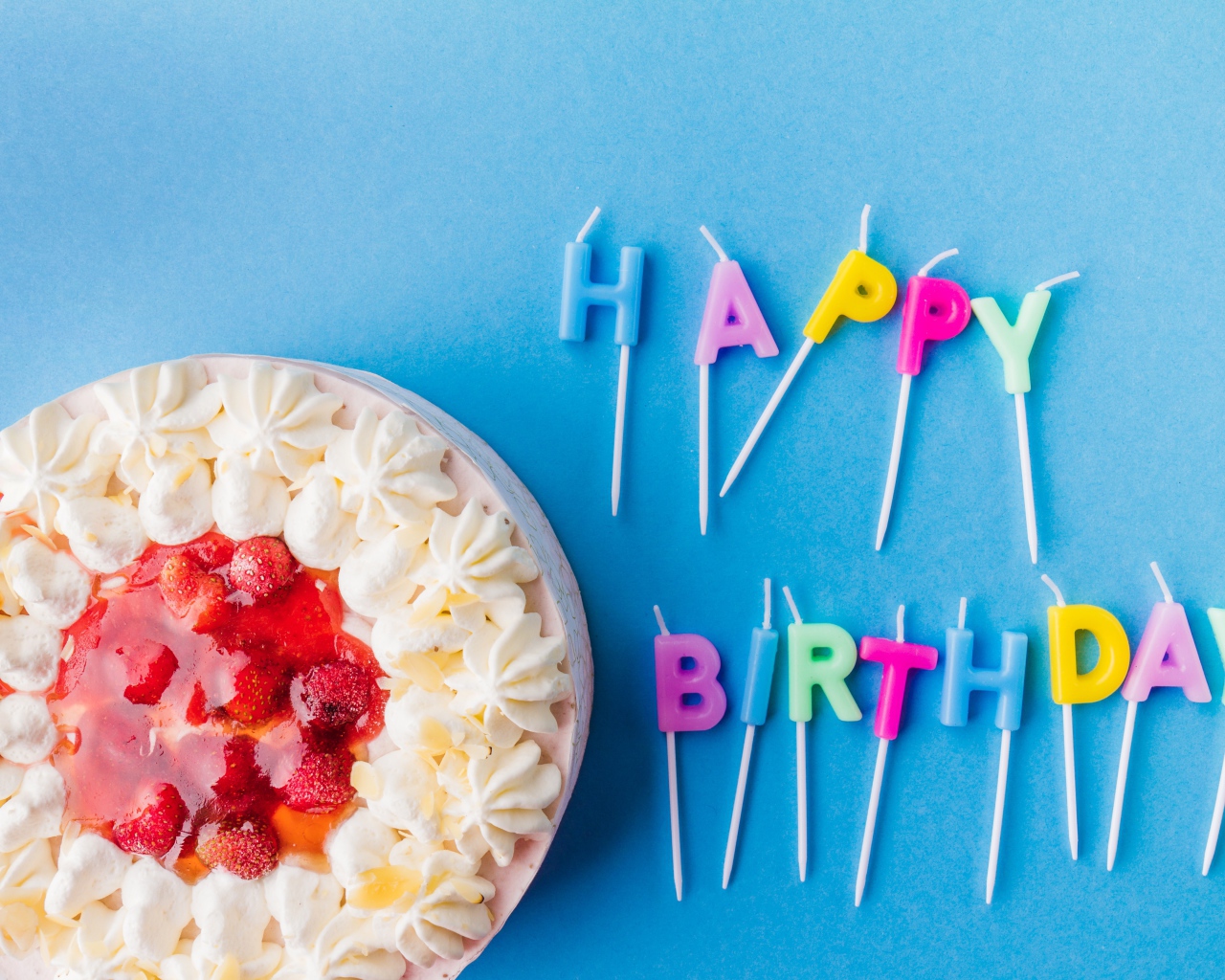 Красивый торт с кремом и клубникой на голубом фоне со свечами на день рождения