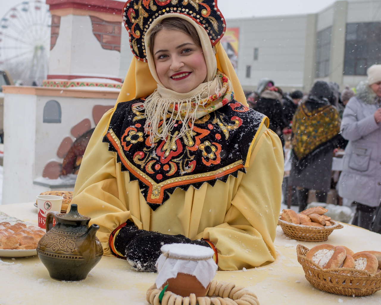 Красивая молодая девушка с угощениями на Масленицу 2018