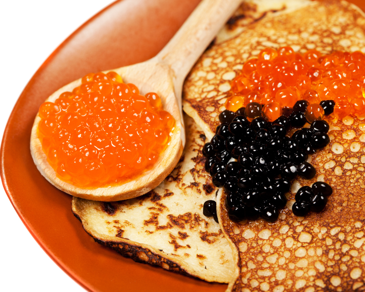 Ruddy appetizing pancakes with red and black caviar on Shrovetide