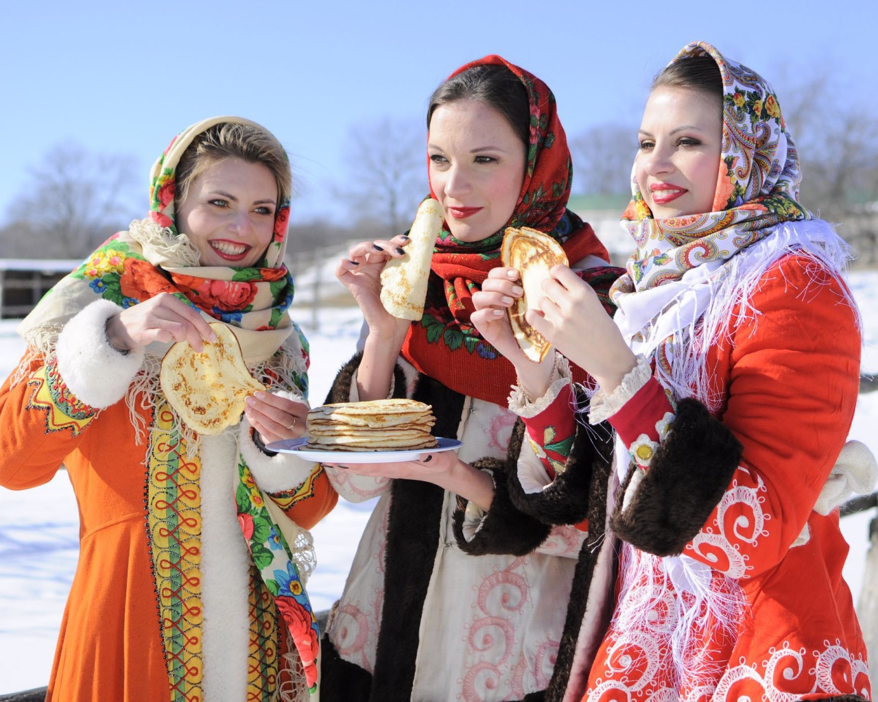 Три молодые красивые девушки с блинами на Масленицу
