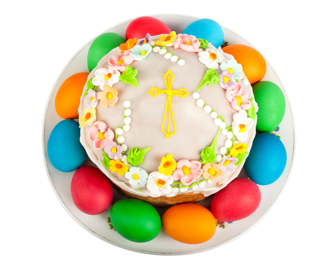 Красивый пасхальный кулич с цветами и разноцветными крашеными яйцами на белом фоне