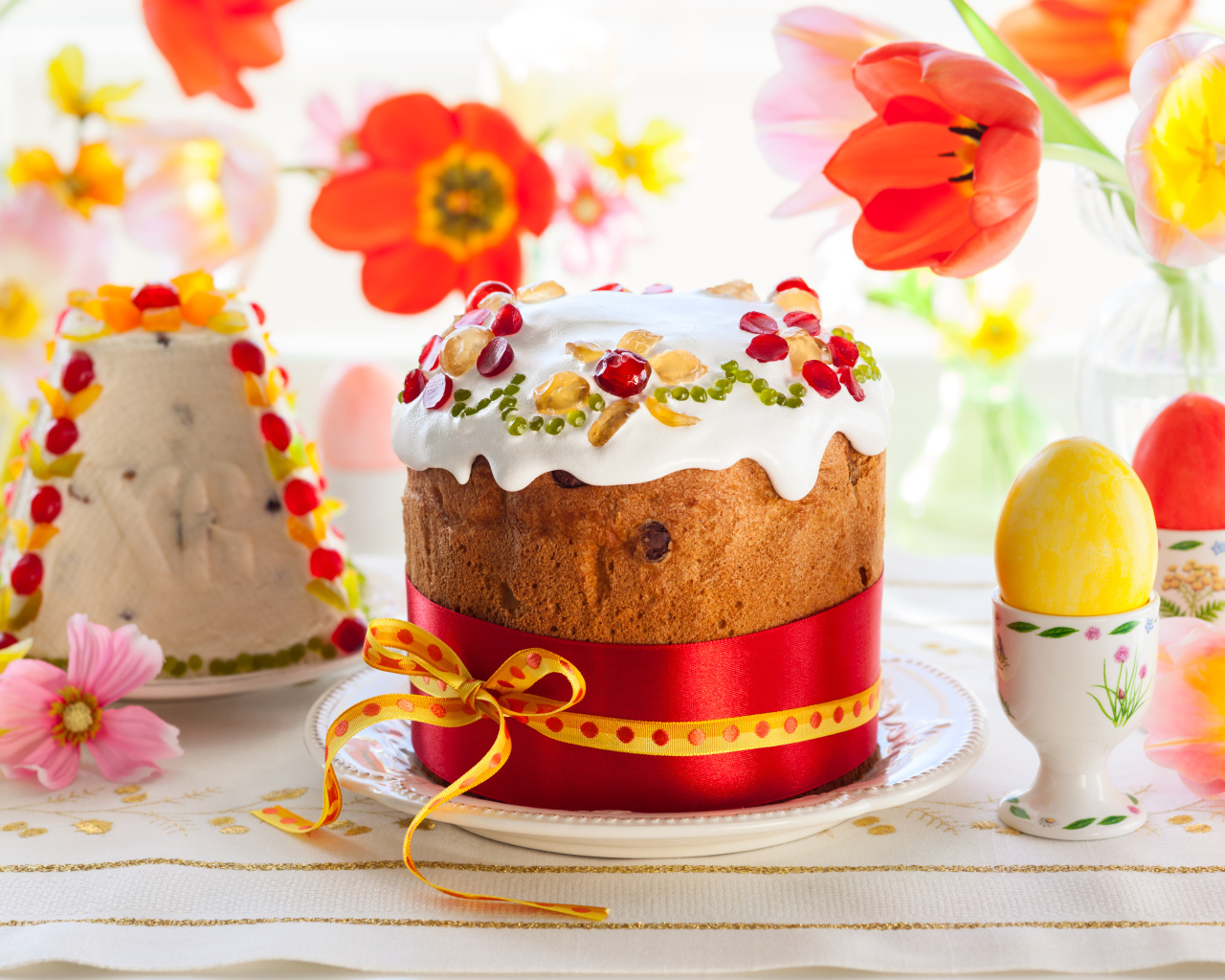Красивые пасхальные куличи на столе с цветами и яйцами