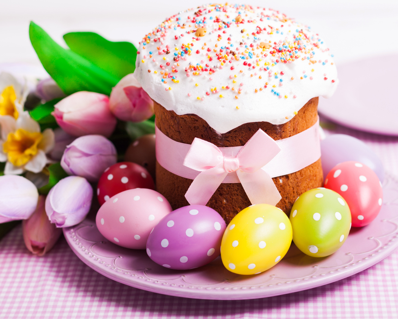 Пасхальный кулич с крашеными яйцами и букетом цветов
