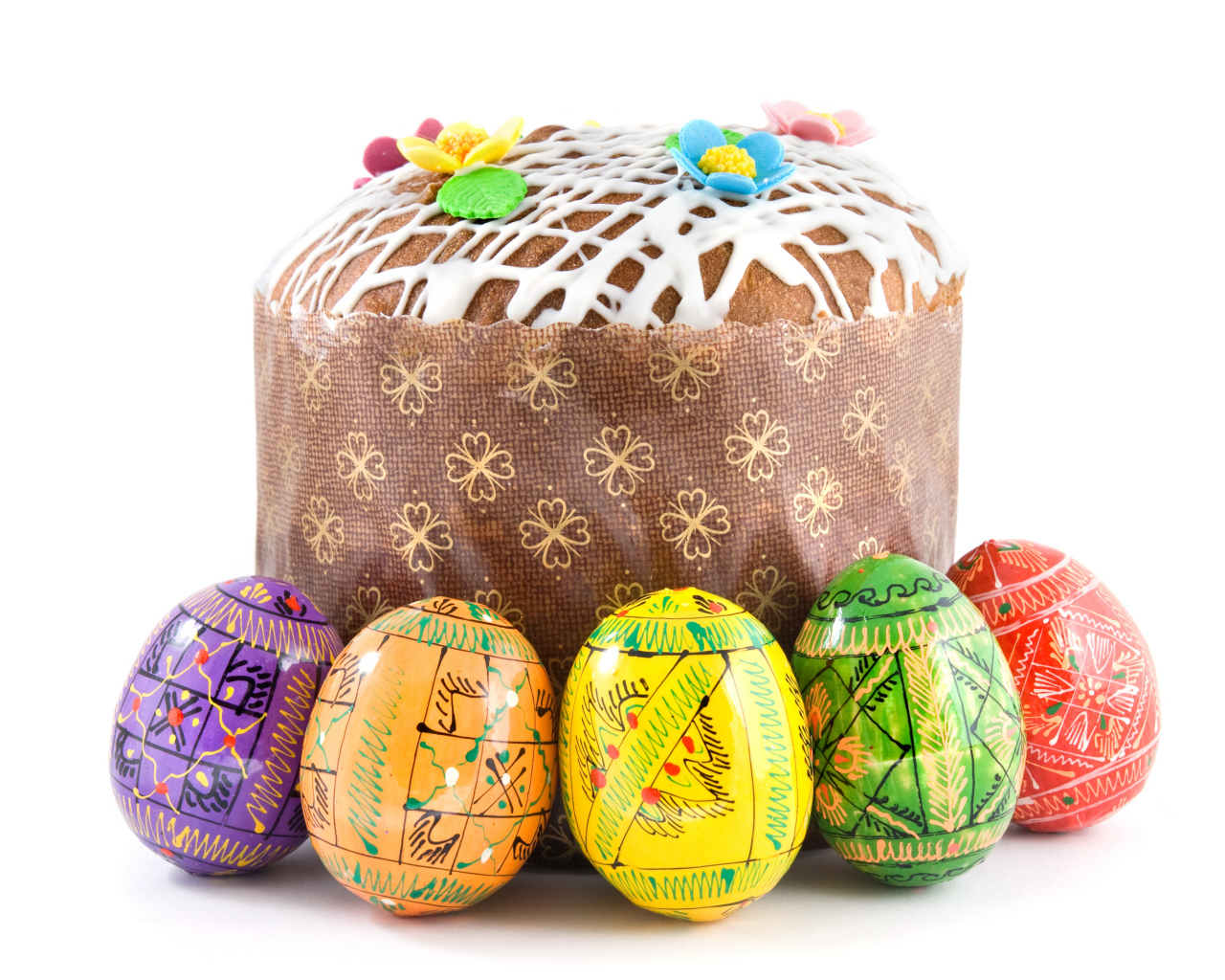 Пасхальный кулич с расписанными яйцами на белом фоне