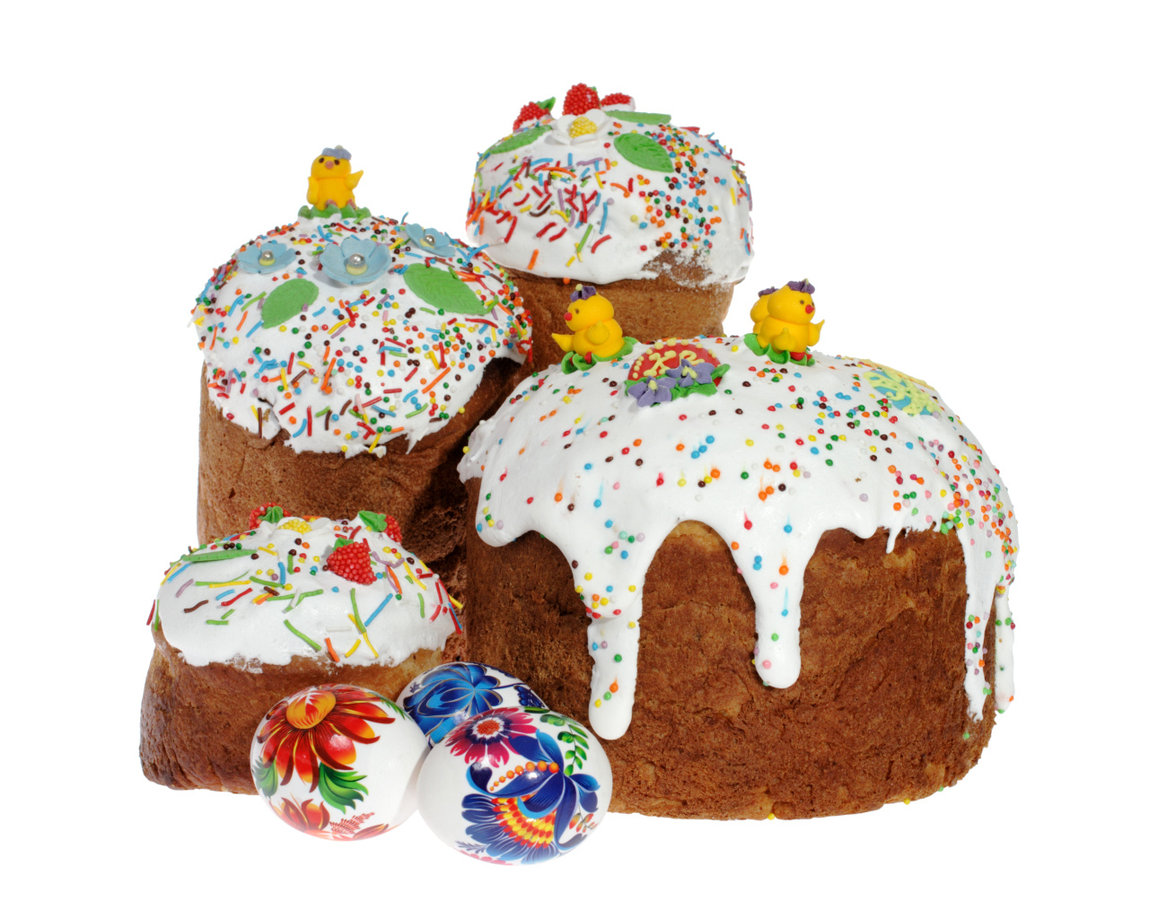Пасхальные куличи с сахарными цыплятами и расписанными яйцами на белом фоне