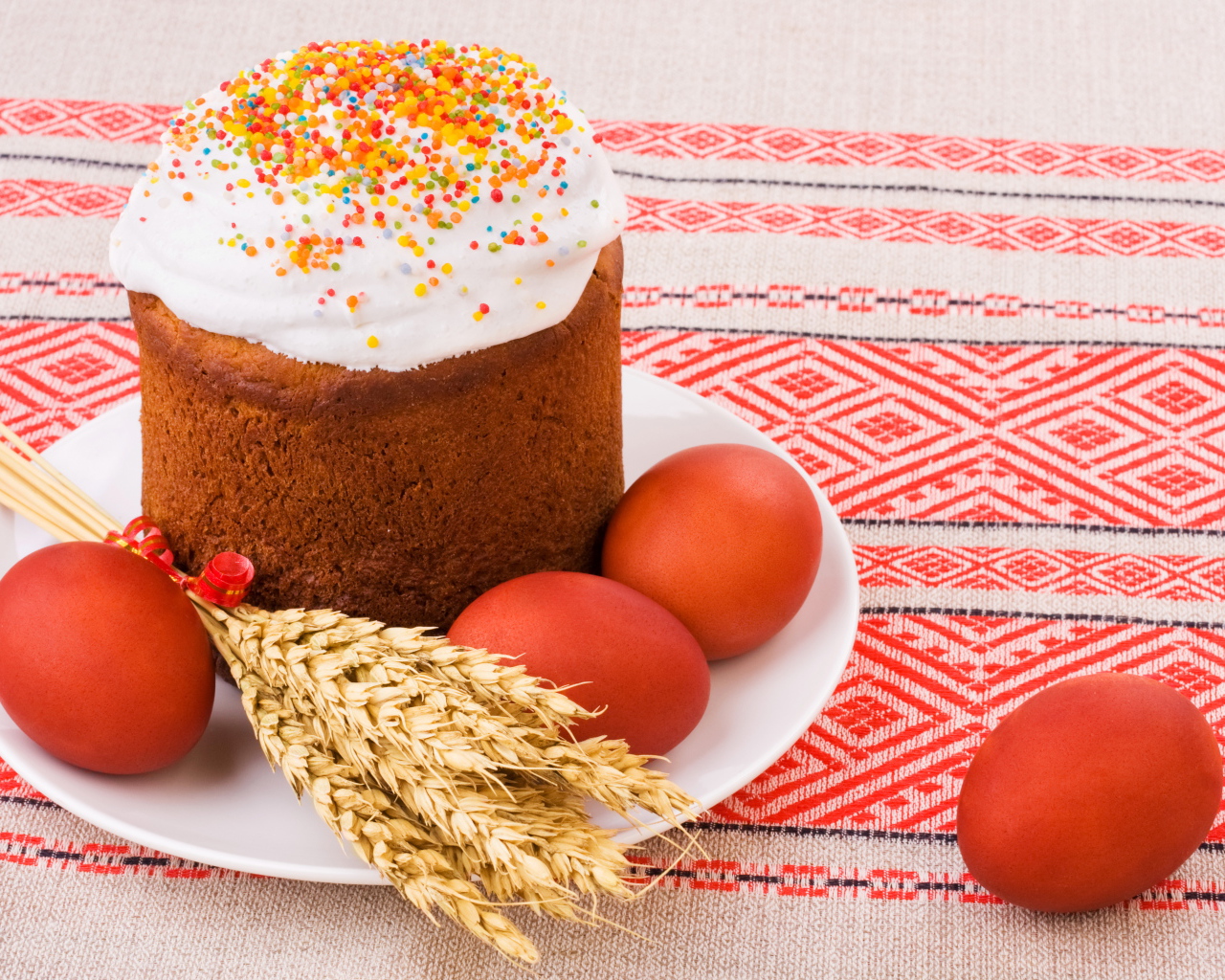 Пасха с крашеными яйцами и колосьями пшеницы на столе с красивой скатертью