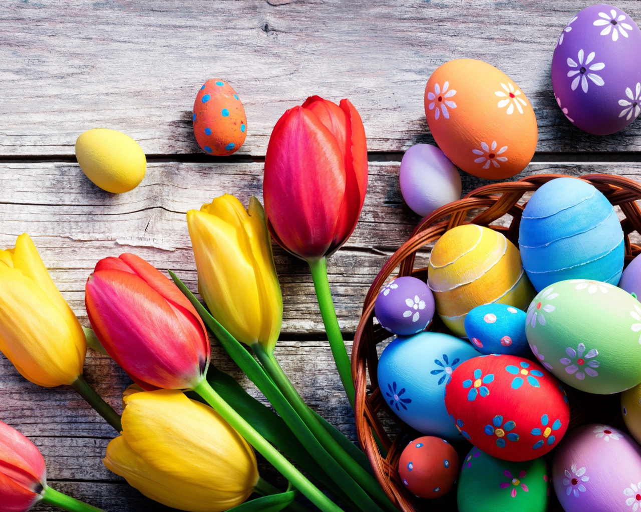 Крашеные яйца на столе с тюльпанами на Пасху