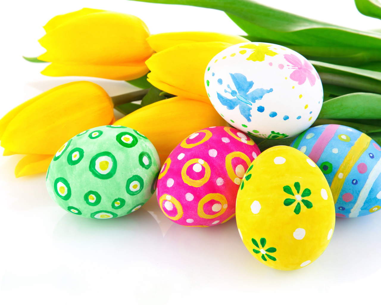 Разукрашенные яйца с букетом желтых тюльпанов на белом фоне на Пасху