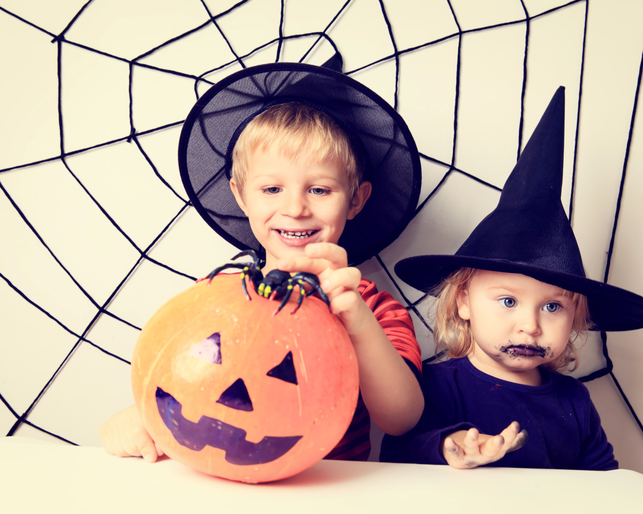 Маленькие мальчик и девочка в костюмах на Хэллоуин