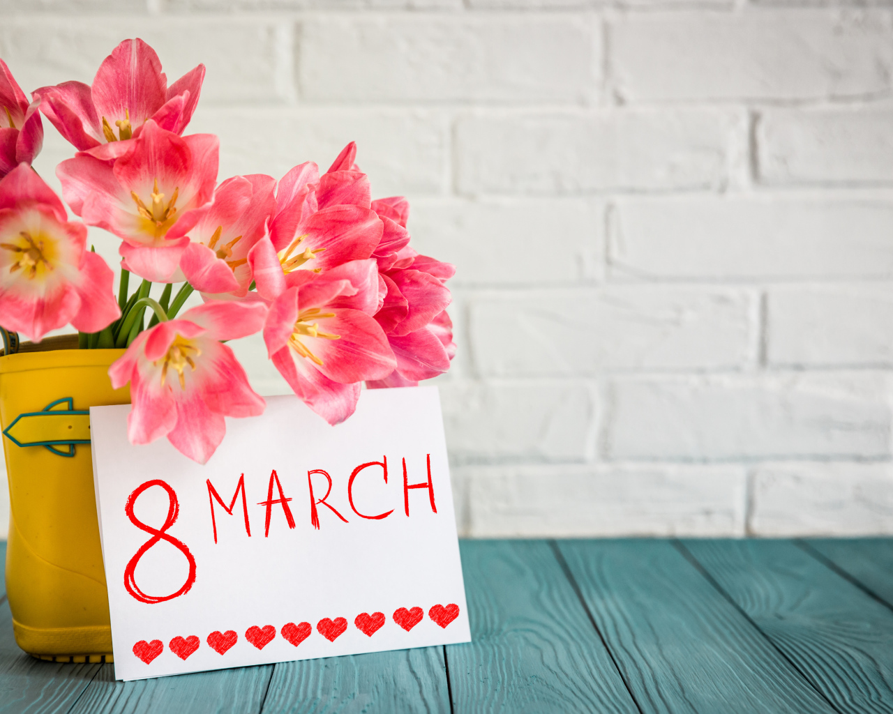Bouquet of tulips and greeting card on the wall background on March 8