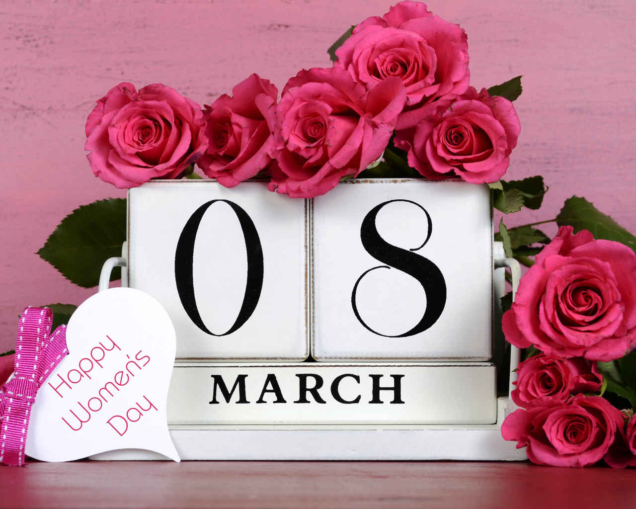 Красные розы на розовом фоне на Международный женский день