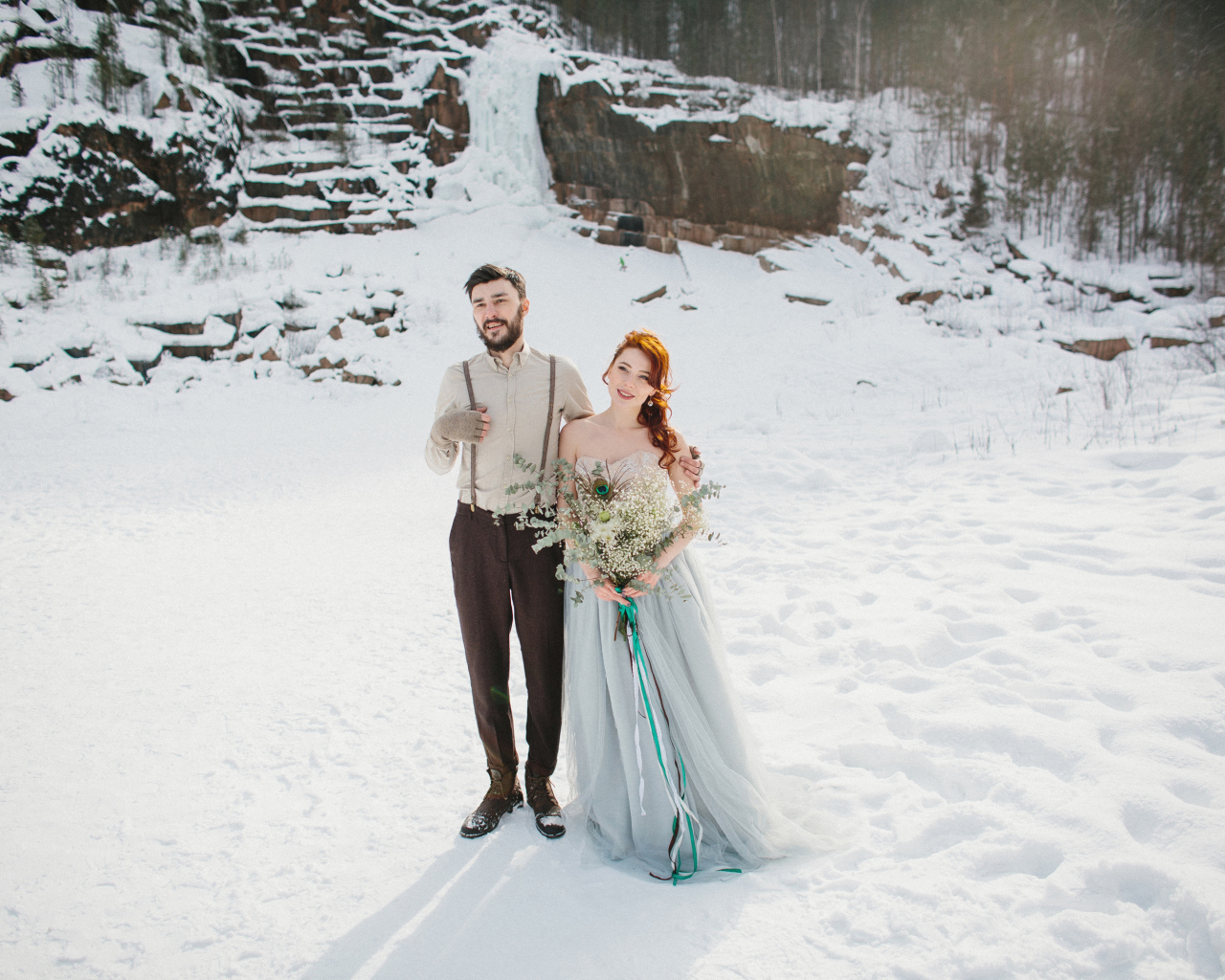 Влюбленная пара молодоженов стоит на снегу