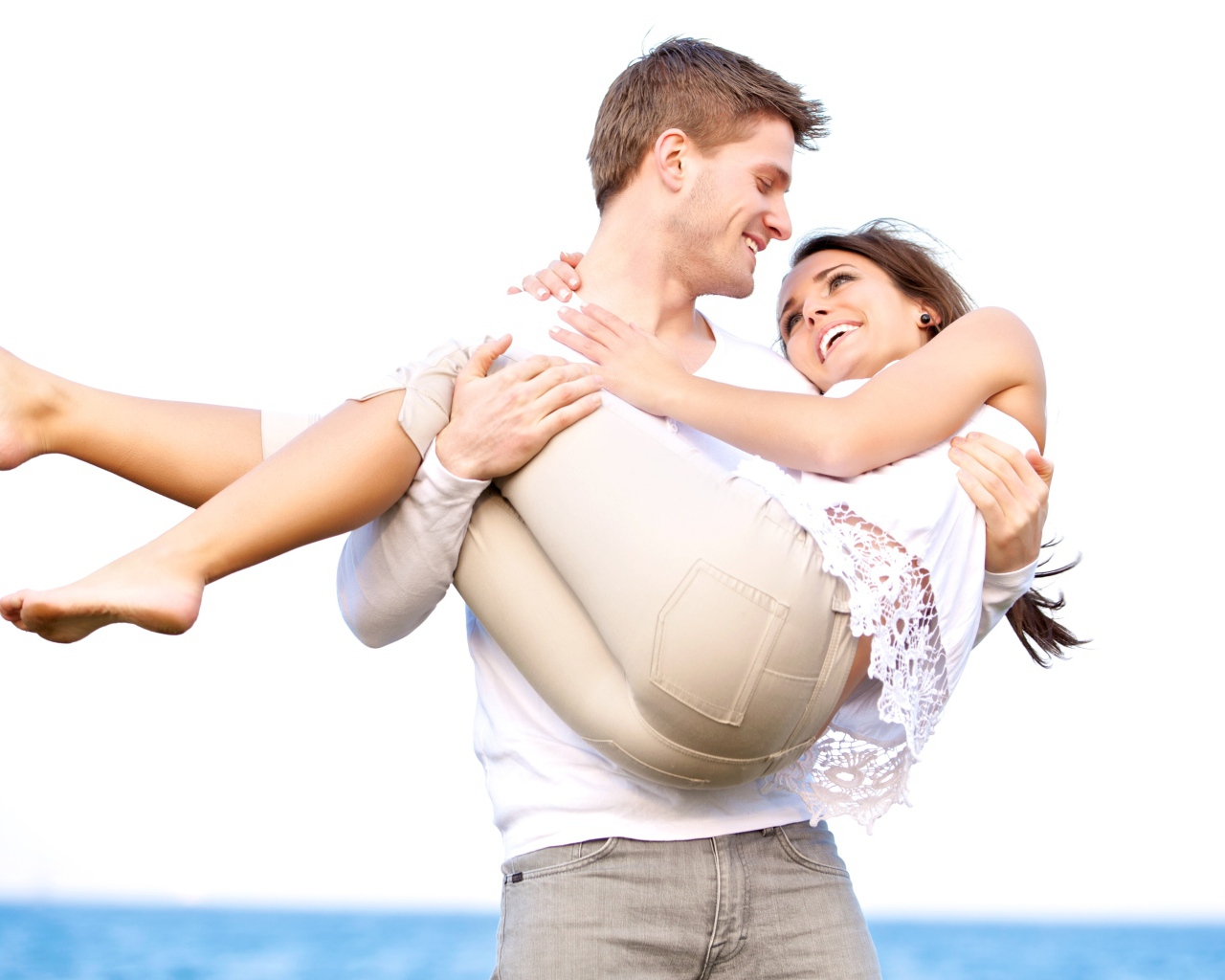 Влюбленный парень держит девушку на руках