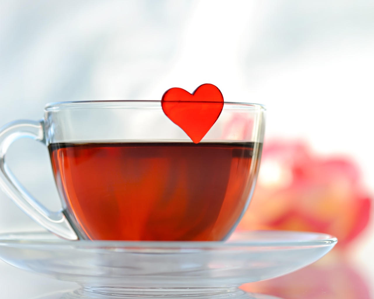 Маленькое красное сердечко в стеклянной чашке с чаем