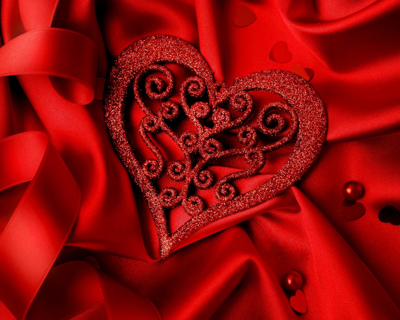 Блестящее сердце на красной атласной ткани 