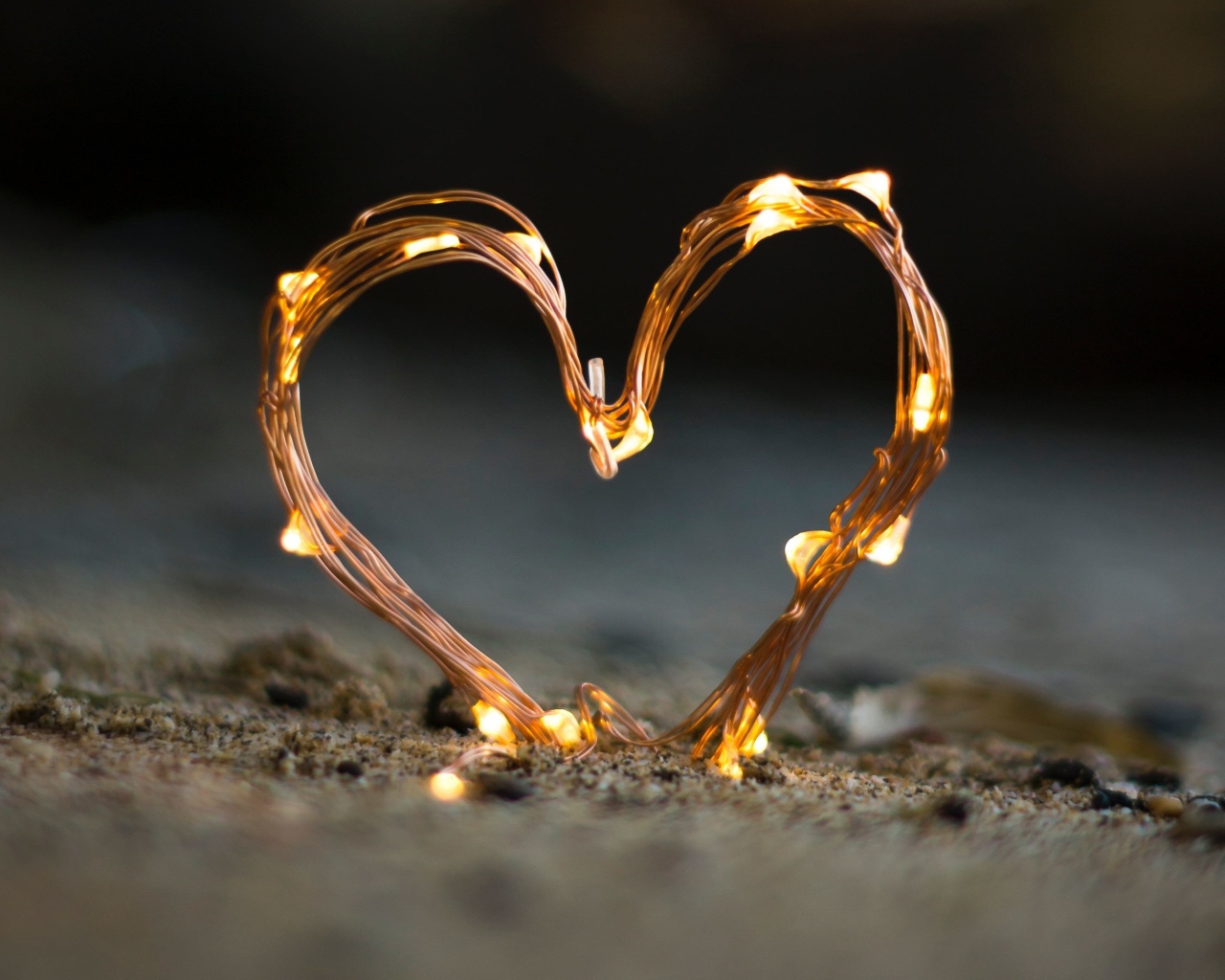 Сердце из гирлянды на песке