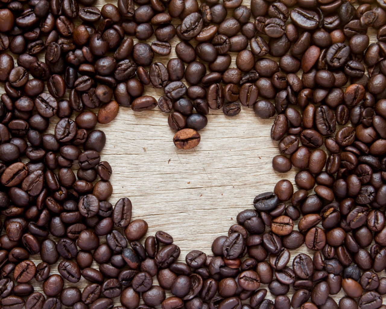 Сердце из кофейных зерен на деревянном столе 