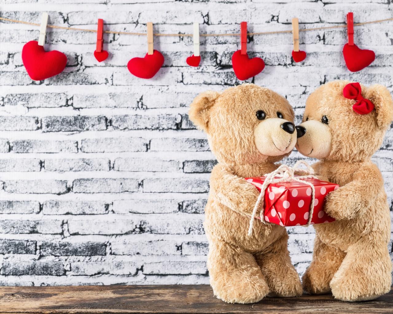 Влюбленные плюшевые мишки на фоне стены с сердечками 