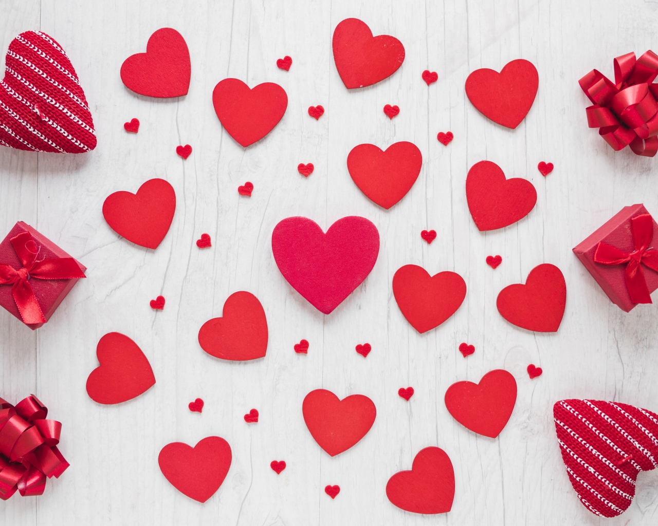 Много красных сердечек на столе с подарками 