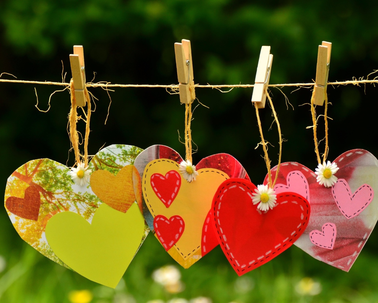 Бумажные сердечки висят на веревке на прищепках