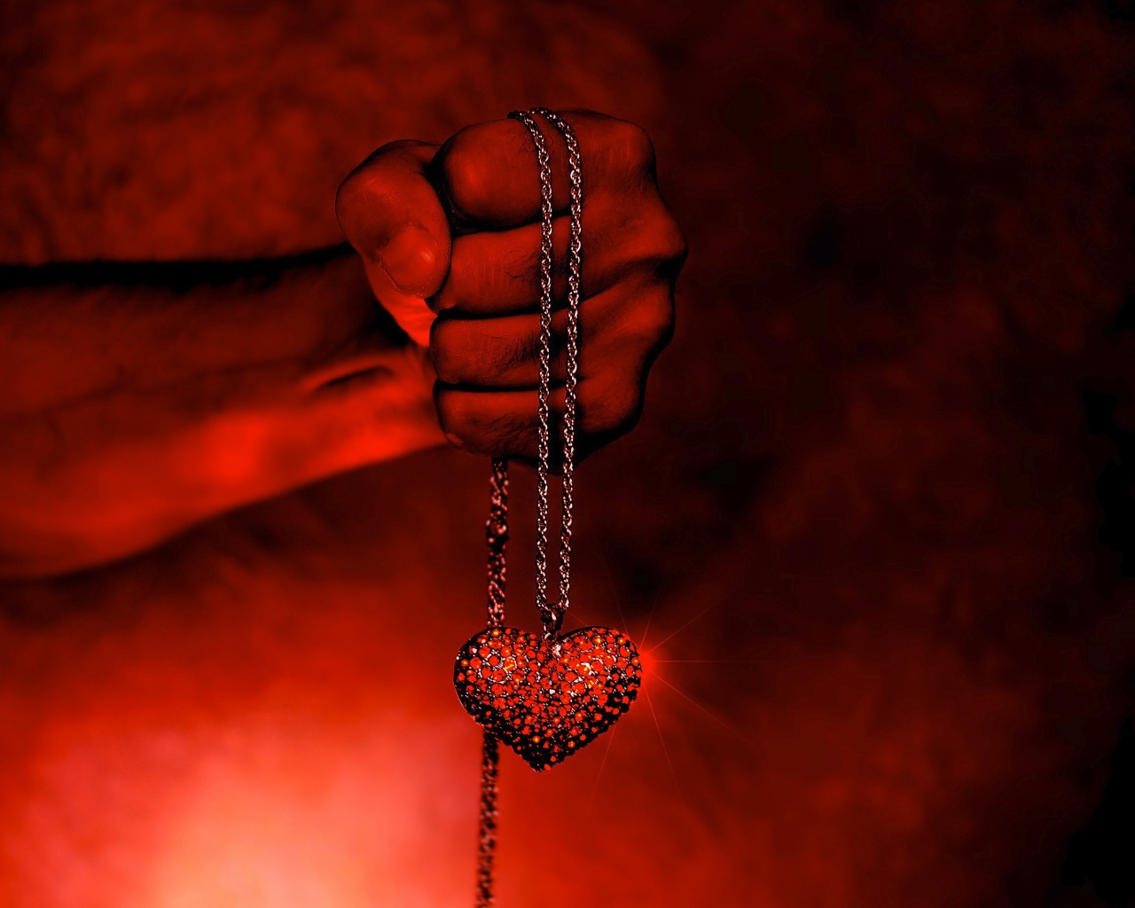 Кулон с сердцем на цепочке в мужской руке 