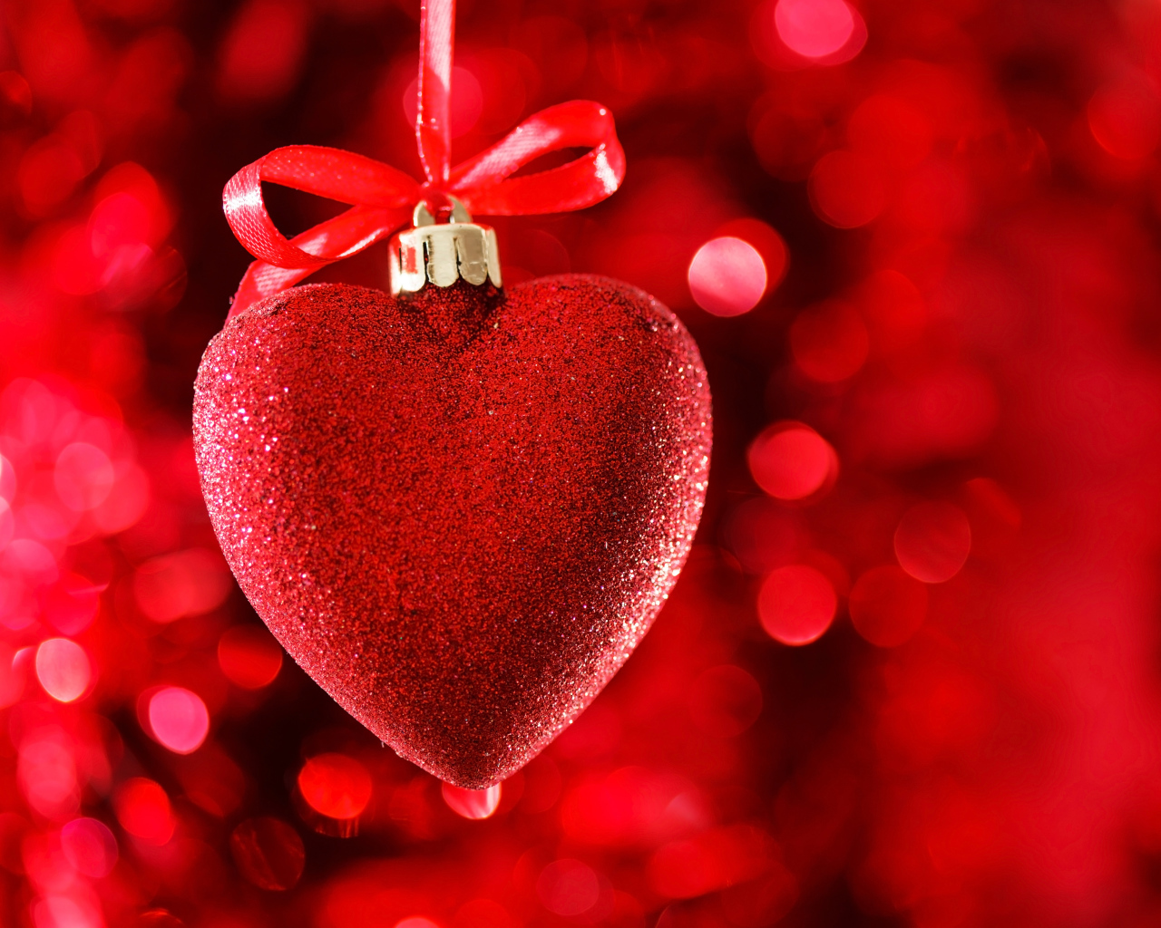 Красное большое блестящее сердце с лентой на красном фоне