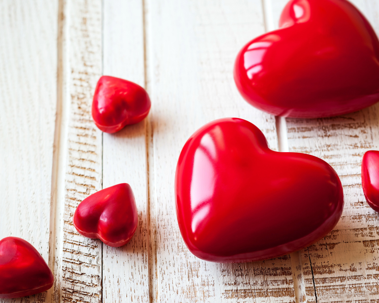Красные сердца на деревянной поверхности 