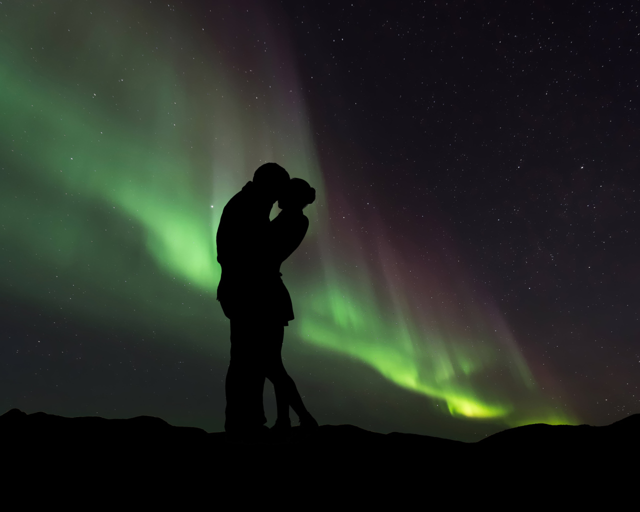 Силуэт влюбленной пары на фоне северного сияния 
