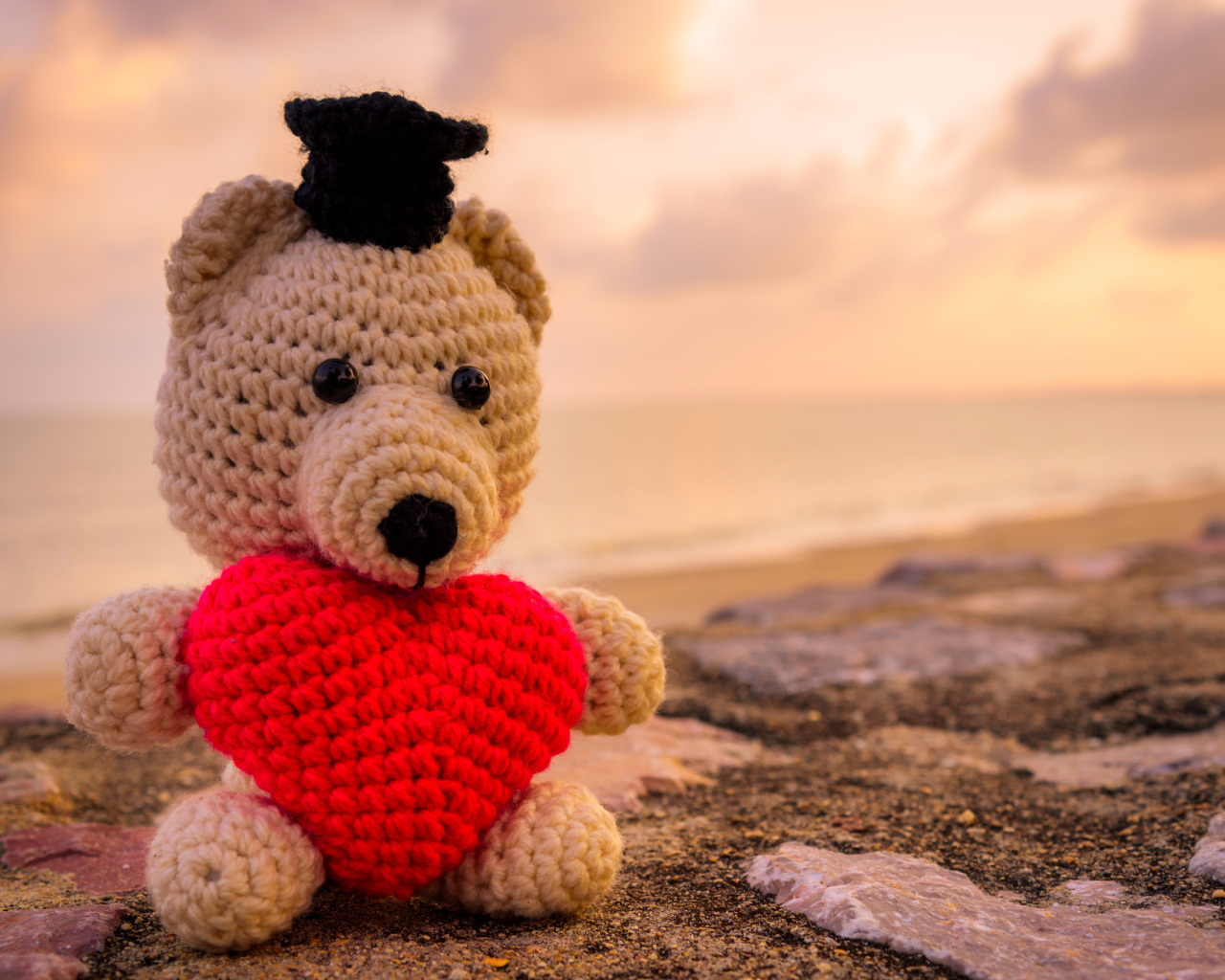 Игрушечный медведь с красным сердцем на фоне неба