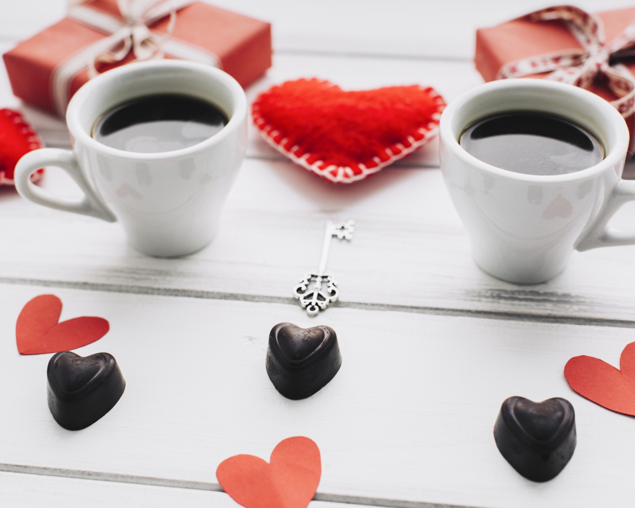 Две чашки кофе на столе с подарками, конфетами и сердечками