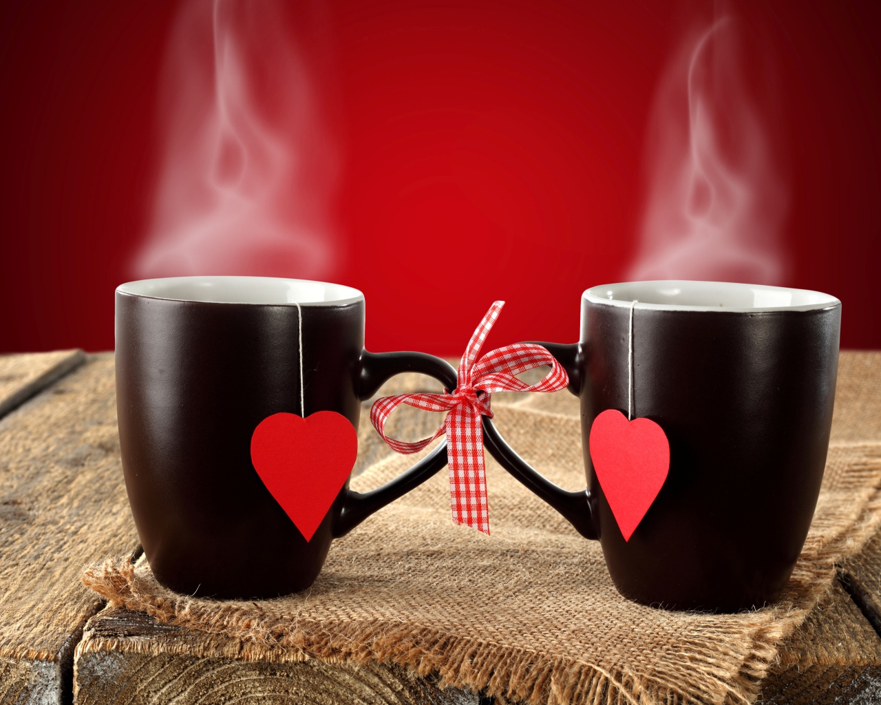 Две чашки горячего чая связаны бантом 