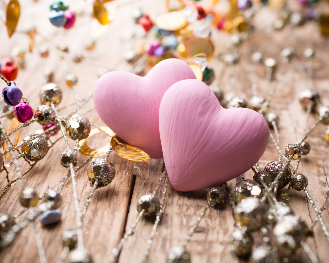 Два розовых сердца на деревянном фоне с элементами декора