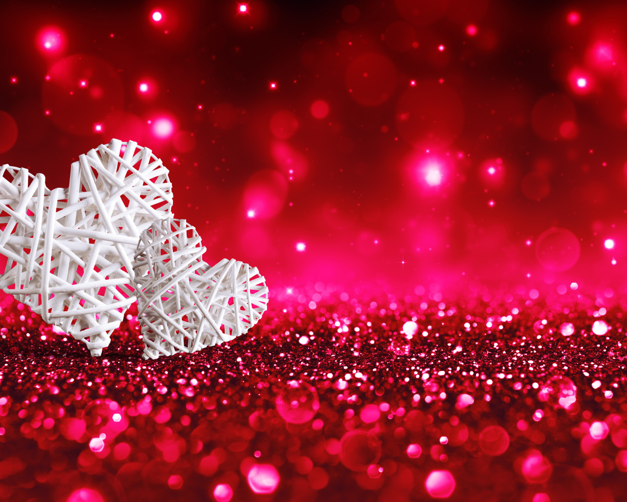 Два белых плетеных сердца на мерцающем красном фоне