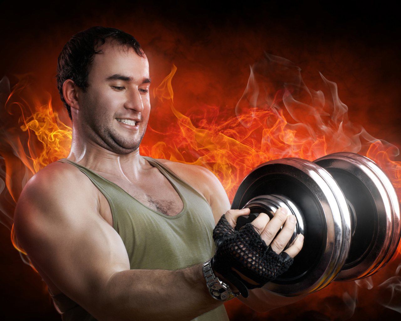 Мужчина спортсмен держит в руках гантелю на фоне огня