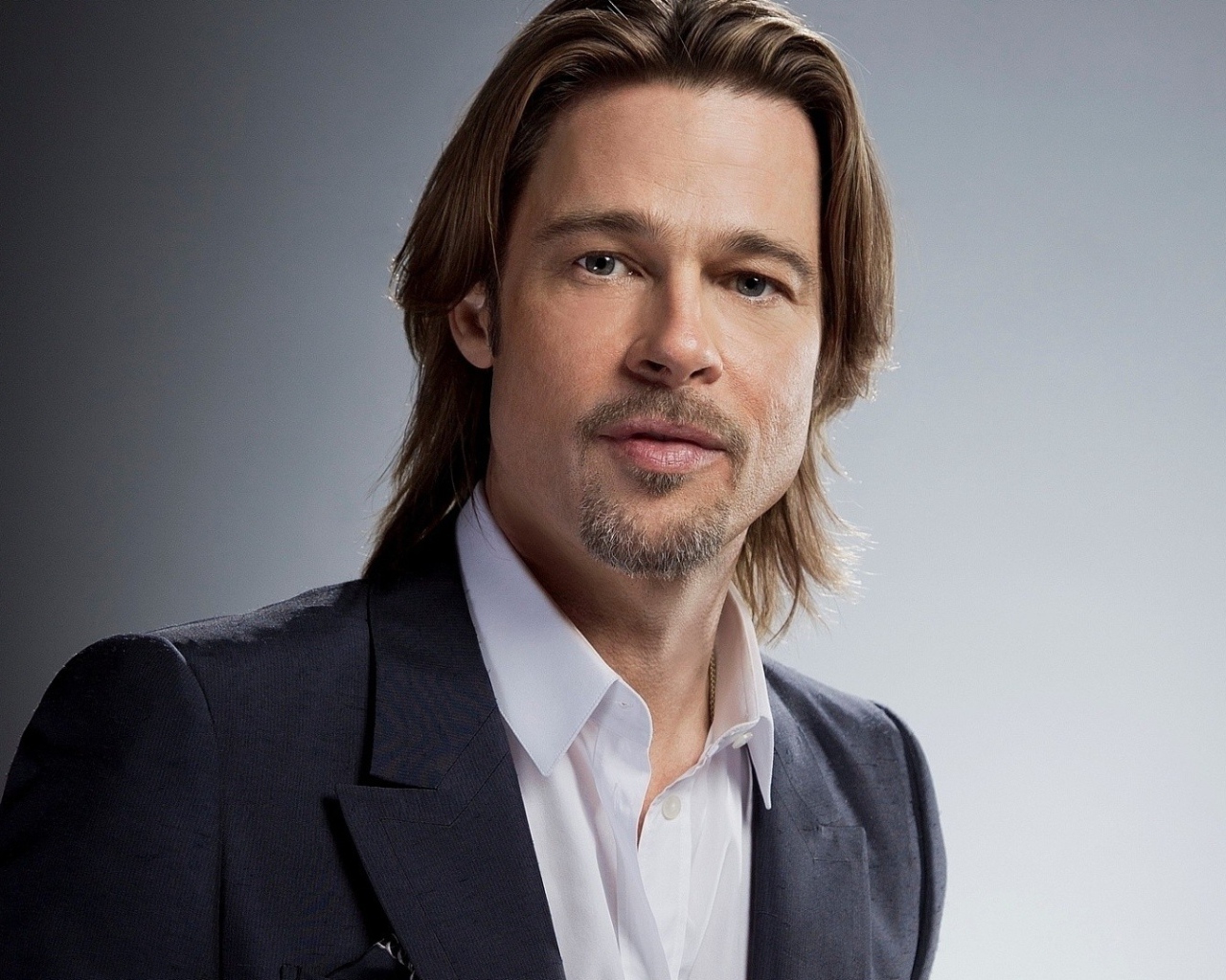 Актер Брэд Питт в костюме на сером фоне